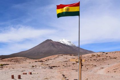 bandera de bolivia frente a un volcán