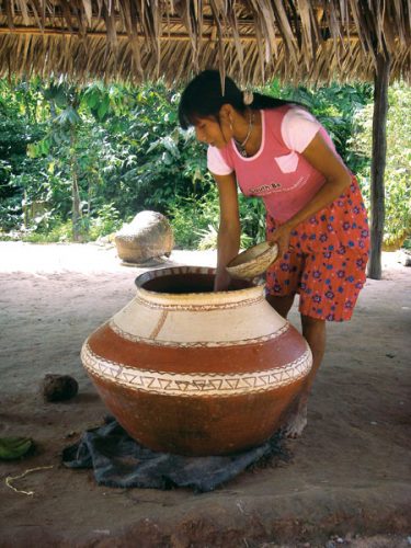 A woman member of Ashaninka's community serving masato