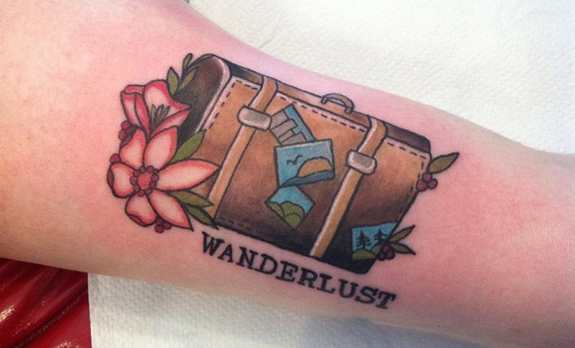 wanderlust travel tattoo and a colored bag