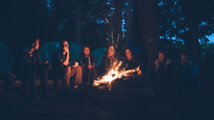 group of people doing a bonfire in the rainforest 