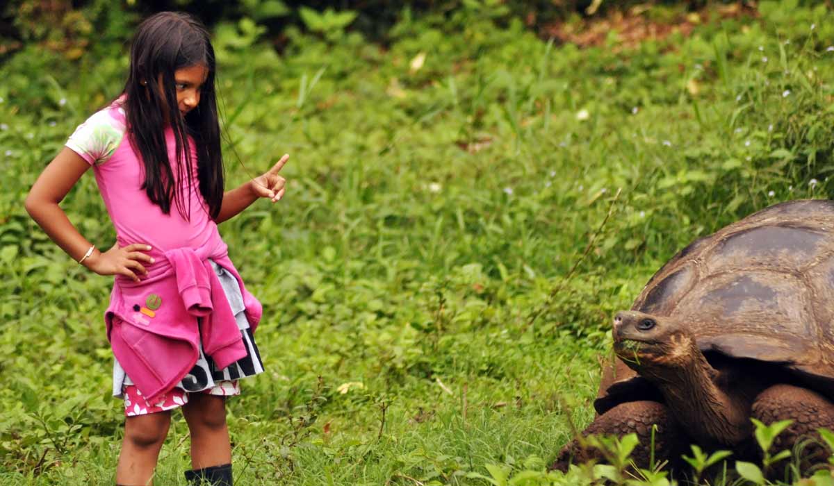niña con una tortuga en las islas galápagos