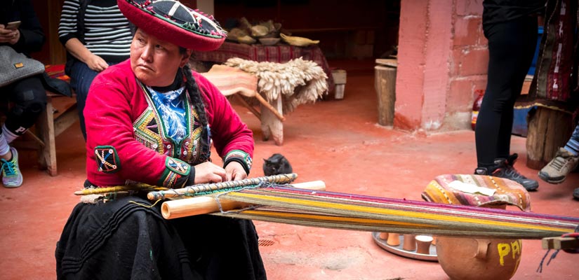 mujer tejiendo ropa tradicional en mercado