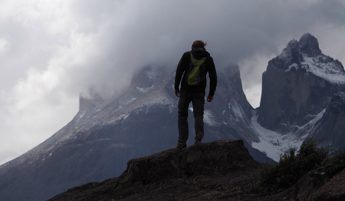 person on top of the mountain in torres del paine