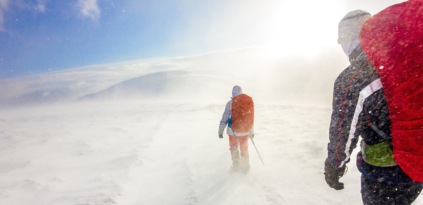 dos personas en un trekking con condiciones adversas de nieve y frio