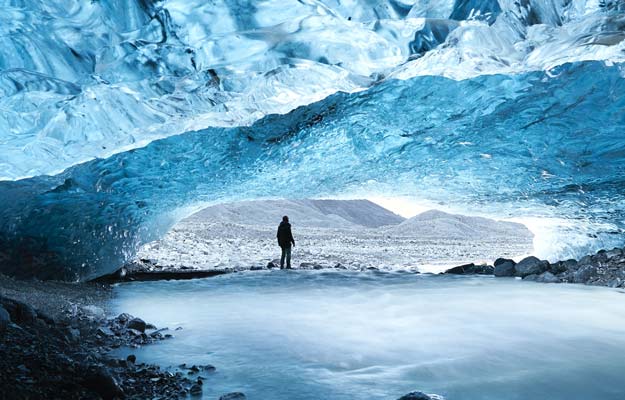 turista en una cueva de hielo azul